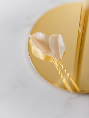 Close-up of a sophisticated gold hairpin with delicate floral accents on a marble surface for a stylish look.