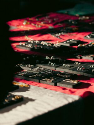Close-up of assorted jewelry pieces elegantly displayed under warm lighting on fabric.