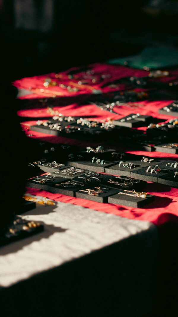 Close-up of assorted jewelry pieces elegantly displayed under warm lighting on fabric.