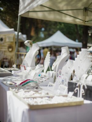 Elegant outdoor jewelry stall showcasing luxury accessories at a market under tents.