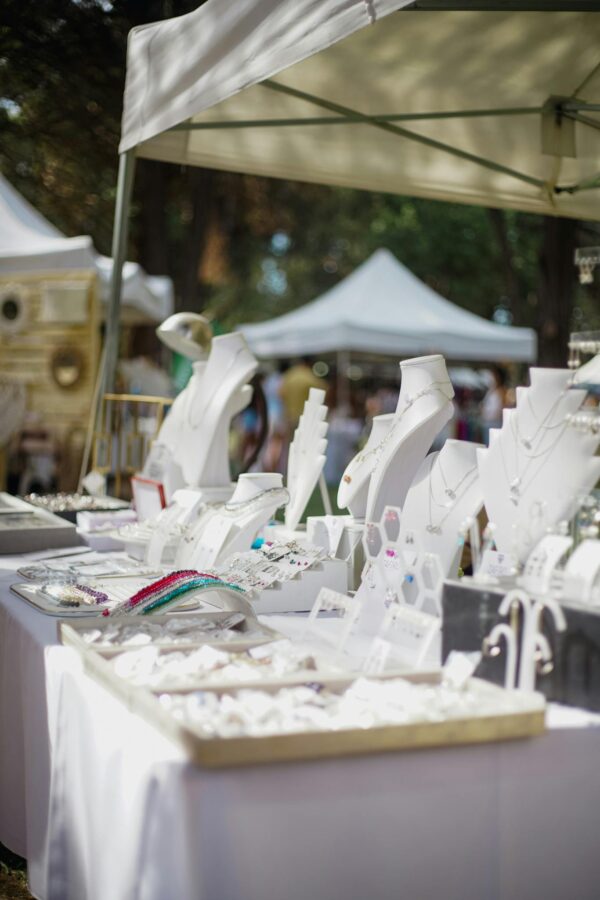 Elegant outdoor jewelry stall showcasing luxury accessories at a market under tents.